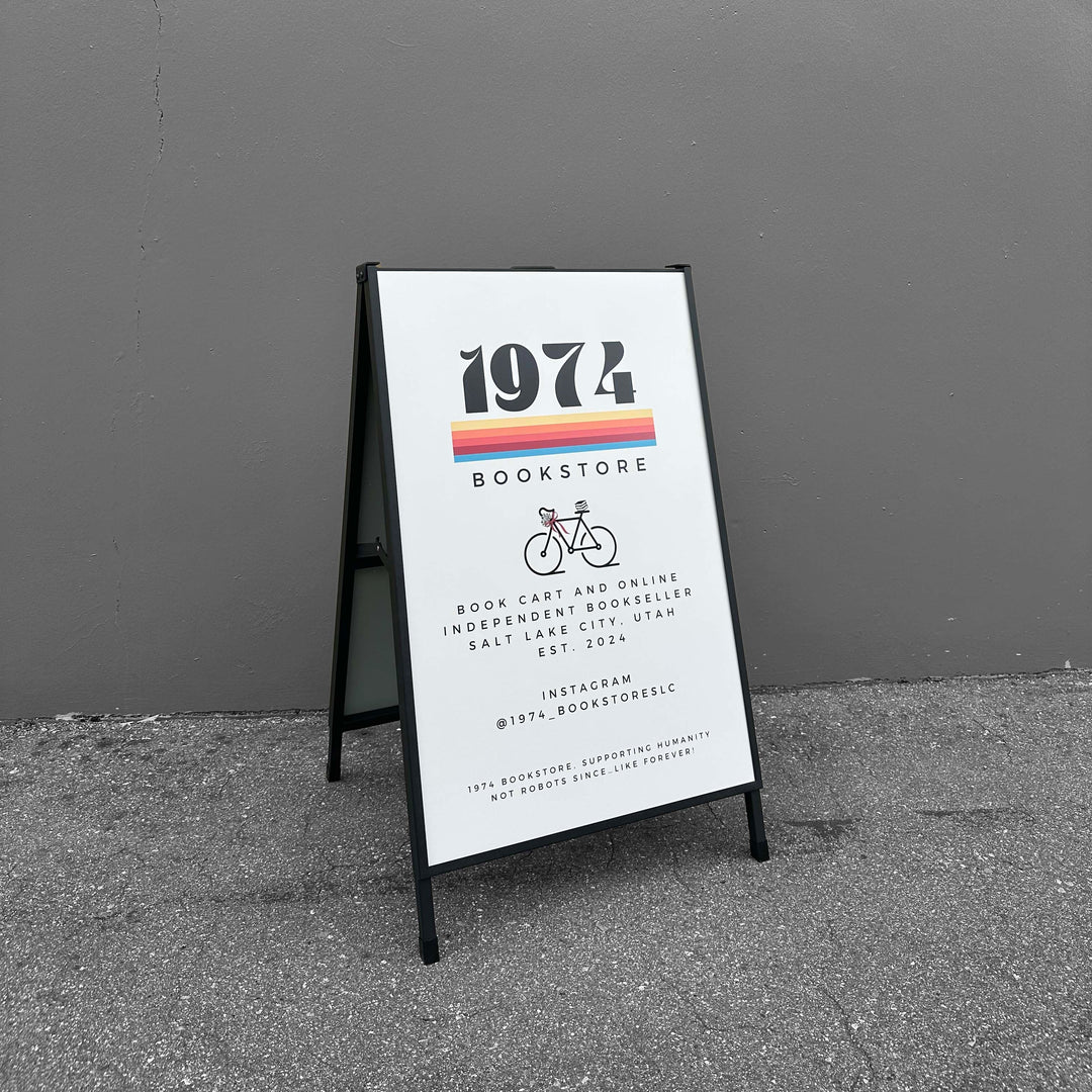 A-frame sign for 1974 Bookstore against a gray wall.